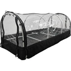 "Portable greenhouse with a transparent plastic cover, zippered sides, and a metal shelving unit inside. The structure is designed for plant propagation and protection."